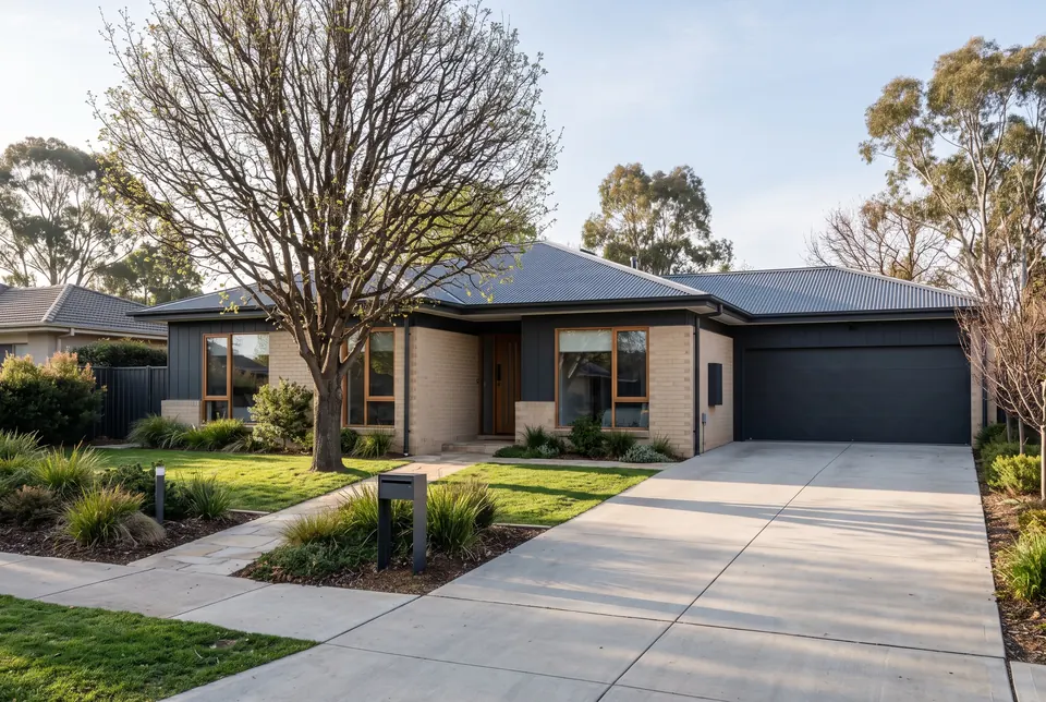Single-storey Deakin home in pale brick and dark cladding under a deciduous tree